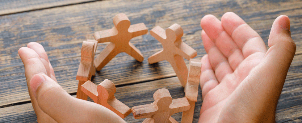 business-success-concept-on-wooden-table-top-view-hands-protecting-wooden-figures-of-people