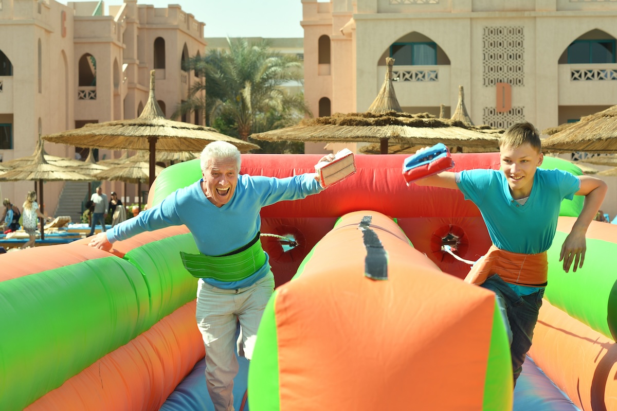 Abuelo y nieto divirtiéndose en un castillo hinchable